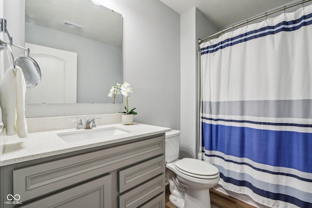 bathroom featuring visible vents, toilet, vanity, wood finished floors, and a shower with curtain