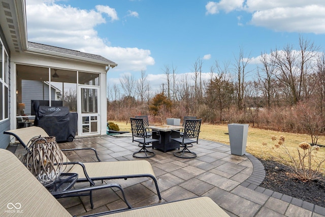 view of patio with a sunroom, outdoor dining area, and area for grilling