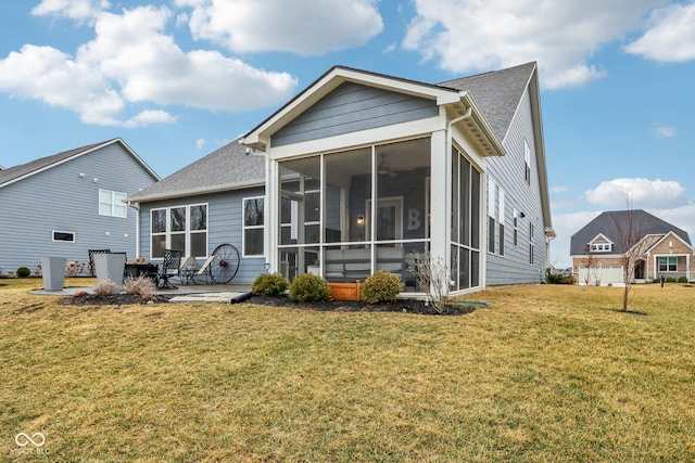 rear view of house featuring a yard, a shingled roof, a patio area, and a sunroom