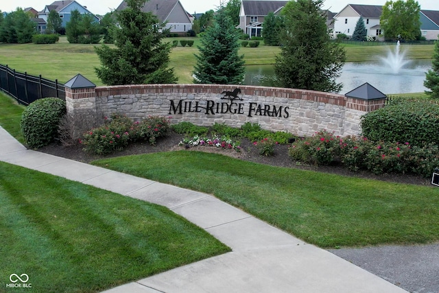 community sign with a residential view, a water view, a yard, and fence