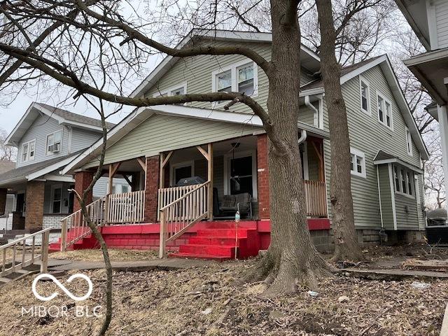 view of front of house with a porch and brick siding