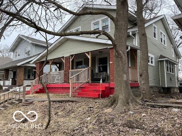 view of front of home with a porch and brick siding