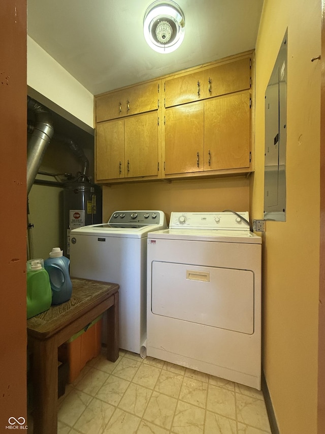 clothes washing area with water heater, cabinet space, electric panel, and washer and clothes dryer