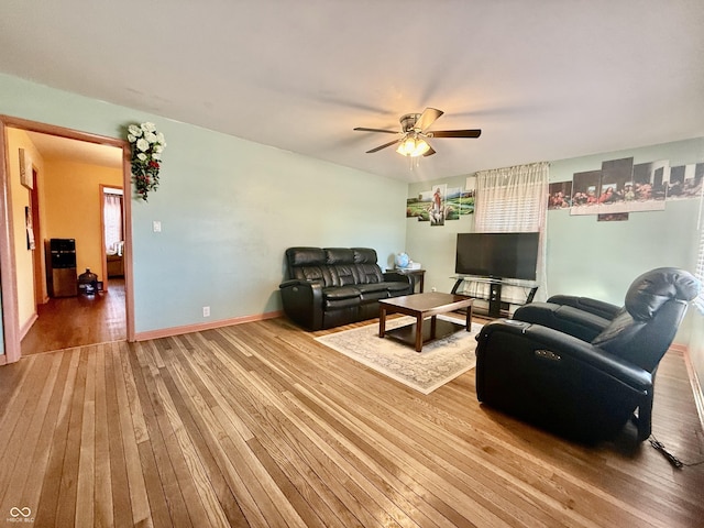 living room with ceiling fan, baseboards, and hardwood / wood-style flooring