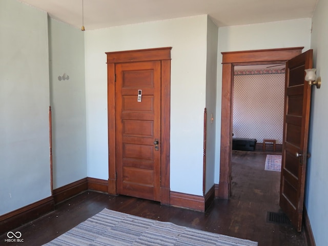 interior space with visible vents, baseboards, and wood finished floors