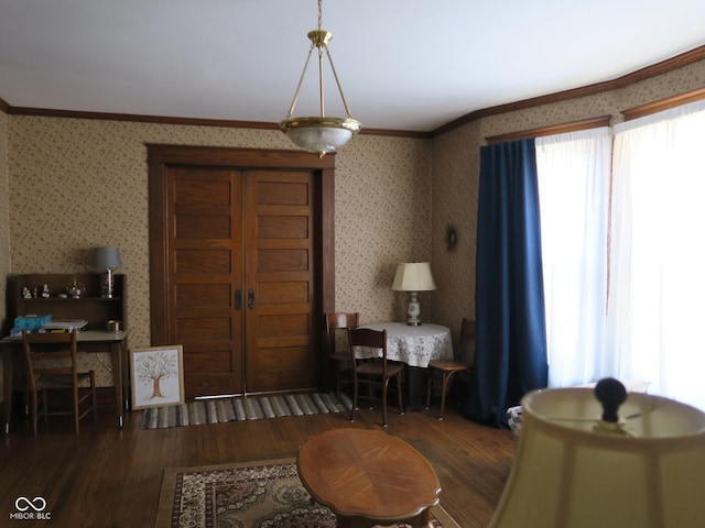 dining room featuring ornamental molding, wood finished floors, and wallpapered walls