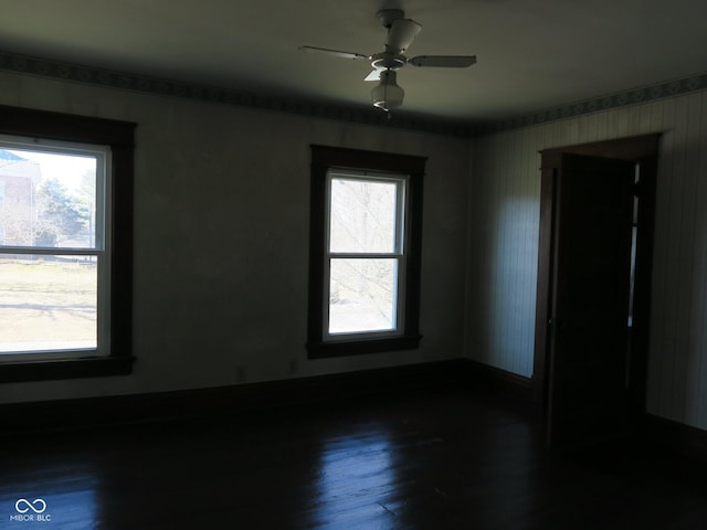 spare room with dark wood-style floors and a ceiling fan