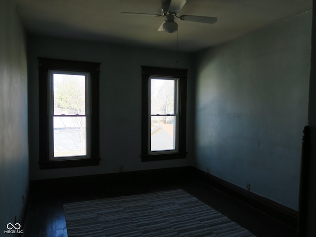 unfurnished room with a ceiling fan and baseboards