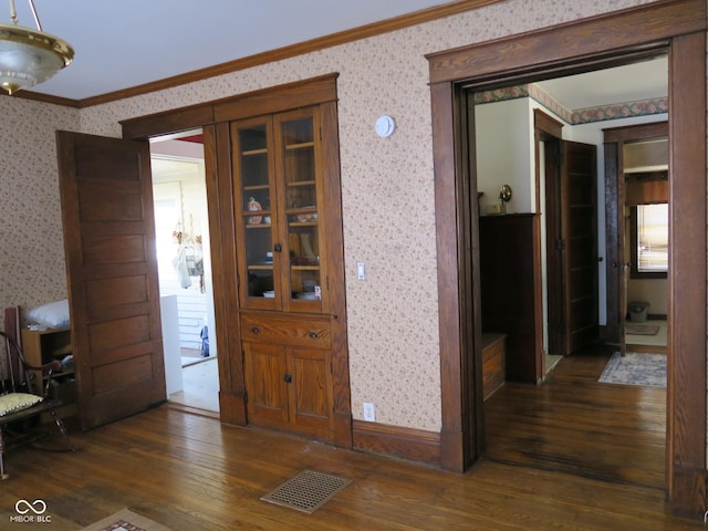 hall featuring visible vents, crown molding, and wallpapered walls