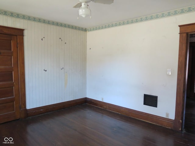 unfurnished room with a ceiling fan, visible vents, baseboards, and wood finished floors