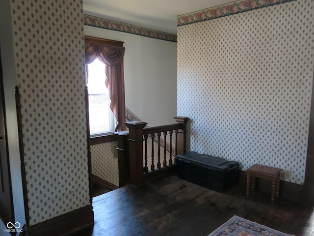 bedroom with wallpapered walls and hardwood / wood-style floors