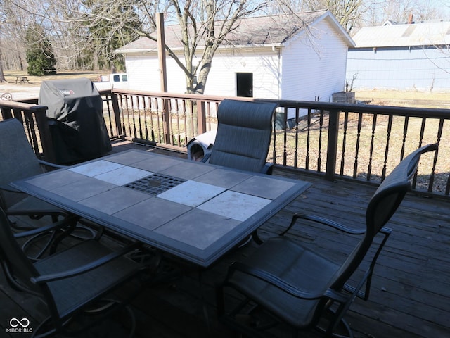 deck with outdoor dining space and area for grilling