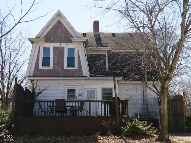 back of property featuring a deck and a chimney