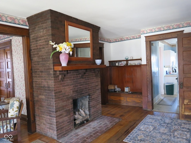 living area with a brick fireplace and hardwood / wood-style floors