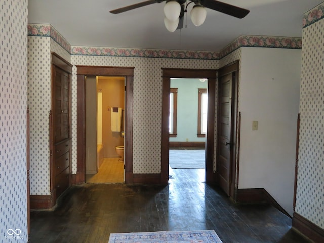 interior space featuring wallpapered walls, baseboards, and hardwood / wood-style floors