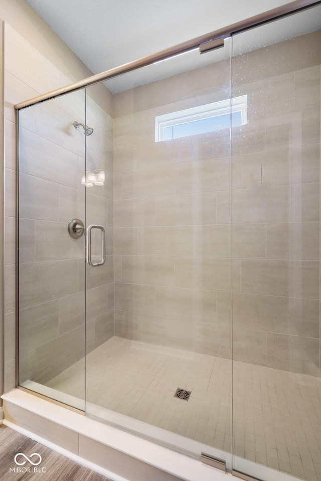 bathroom featuring tiled shower and wood finished floors