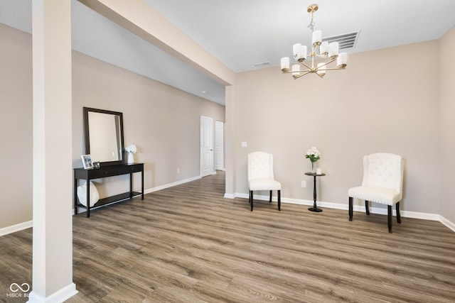 living area featuring a chandelier, dark wood-type flooring, visible vents, and baseboards