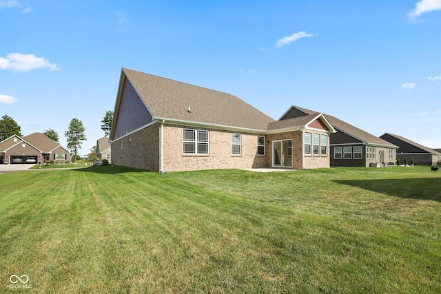 rear view of property with a lawn and brick siding