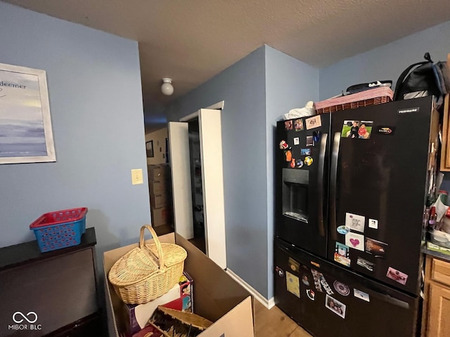 kitchen featuring black refrigerator with ice dispenser