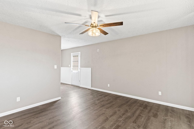 unfurnished room featuring dark wood-style floors, a textured ceiling, baseboards, and a ceiling fan