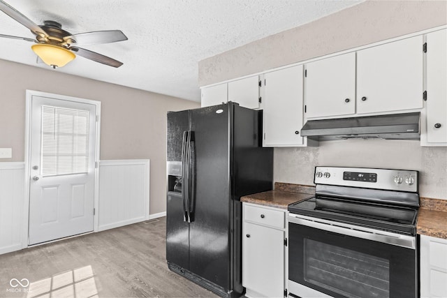 kitchen with dark countertops, stainless steel electric stove, ventilation hood, and black fridge with ice dispenser