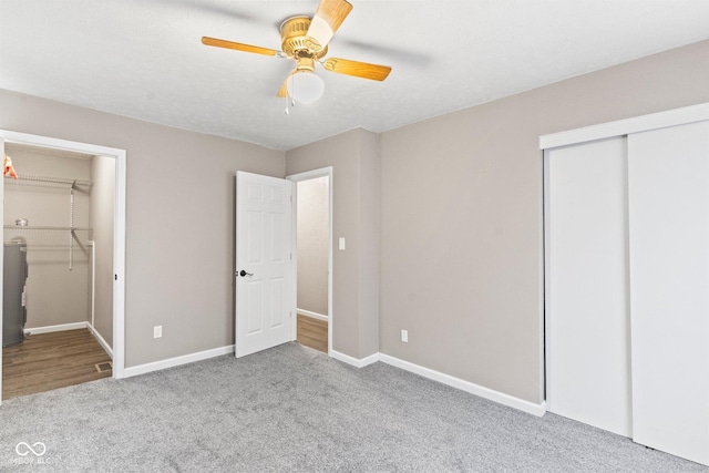 unfurnished bedroom featuring baseboards, ceiling fan, a closet, and light colored carpet