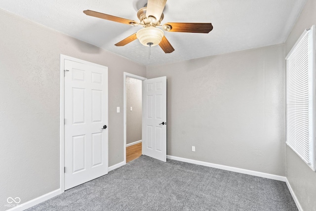 unfurnished bedroom featuring carpet floors, baseboards, and a ceiling fan