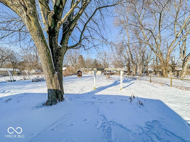 yard layered in snow featuring fence