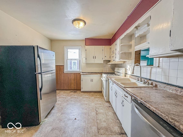 kitchen featuring a wainscoted wall, open shelves, stainless steel appliances, white cabinets, and a sink