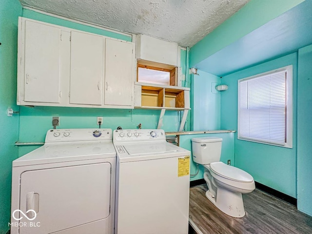 laundry area featuring laundry area, baseboards, dark wood-style flooring, washing machine and clothes dryer, and a textured ceiling