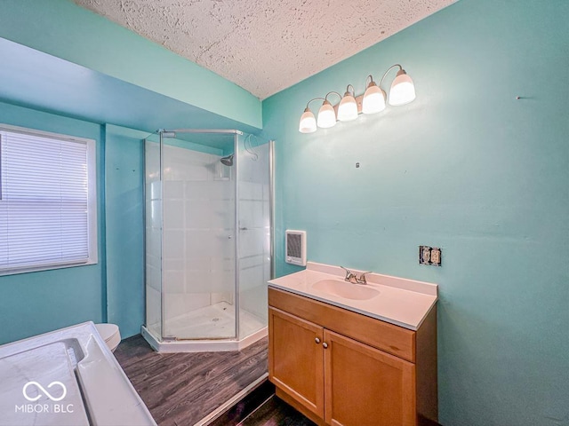 bathroom with wood finished floors, a shower stall, vanity, and a textured ceiling