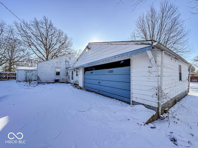 snow covered garage with a detached garage