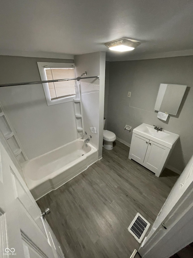 bathroom with visible vents, toilet, washtub / shower combination, vanity, and wood finished floors