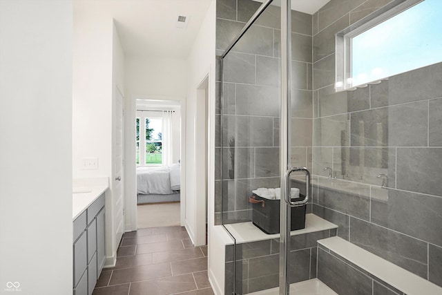 ensuite bathroom featuring tile patterned flooring, visible vents, vanity, a shower stall, and ensuite bath