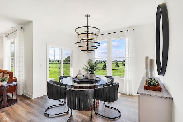 dining space with a notable chandelier, plenty of natural light, and light wood-style floors