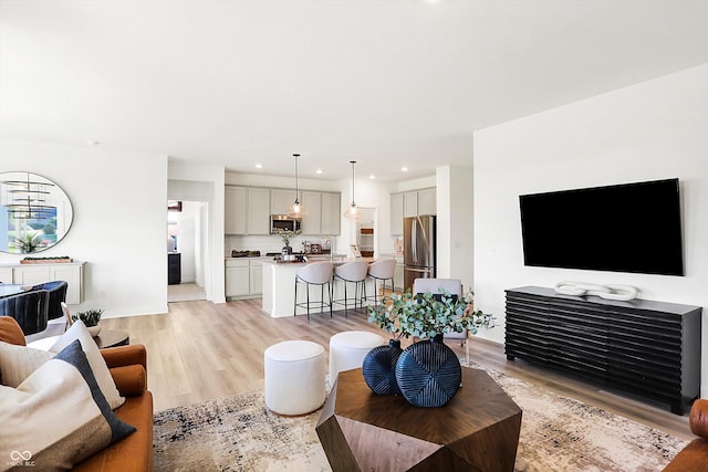 living area featuring light wood finished floors and recessed lighting