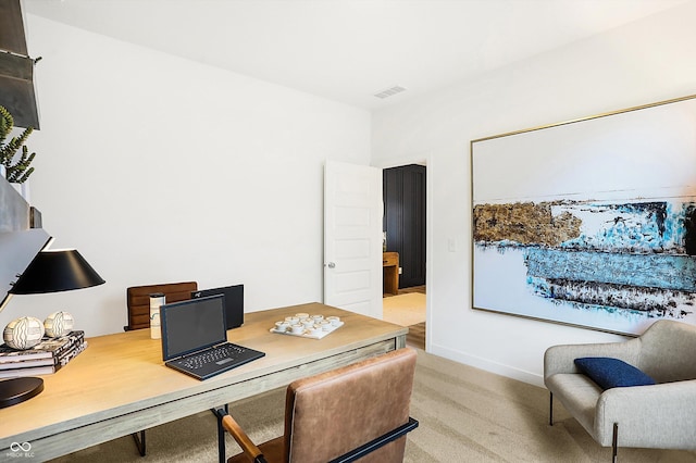 office area featuring visible vents, light carpet, and baseboards