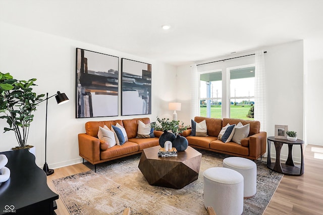 living area with light wood-type flooring and baseboards