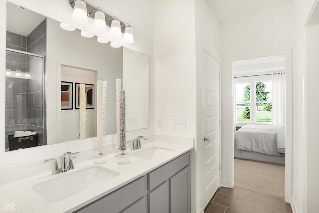 ensuite bathroom featuring double vanity, a stall shower, connected bathroom, and a sink