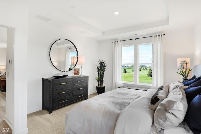 bedroom featuring light carpet, baseboards, visible vents, a tray ceiling, and recessed lighting