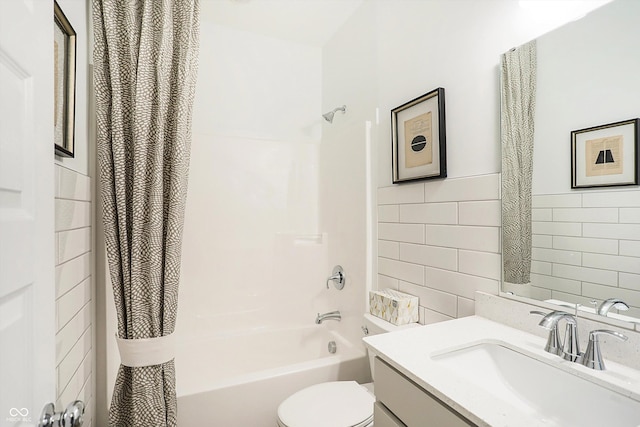 bathroom with toilet, shower / tub combo, vanity, and tile walls