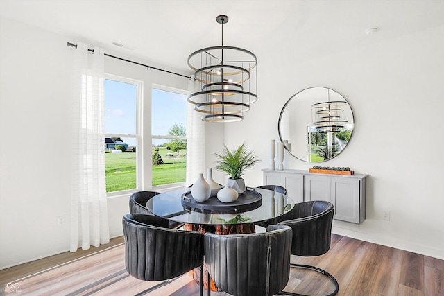 dining room featuring a chandelier, visible vents, and light wood-style flooring