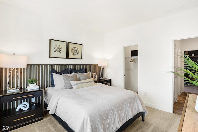 carpeted bedroom featuring a closet, visible vents, and baseboards