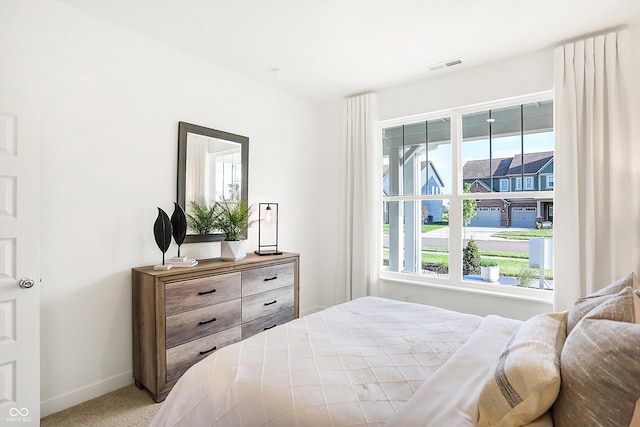 carpeted bedroom with visible vents and baseboards