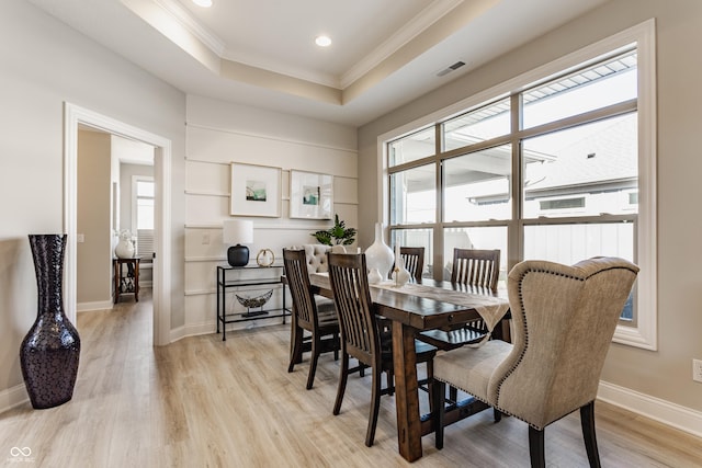 dining room featuring baseboards, crown molding, visible vents, and a tray ceiling