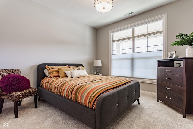 bedroom with light colored carpet, visible vents, and baseboards