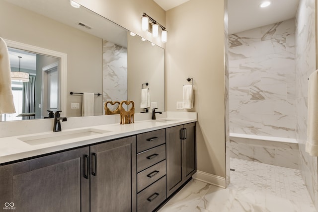 bathroom featuring marble finish floor, double vanity, a sink, and visible vents