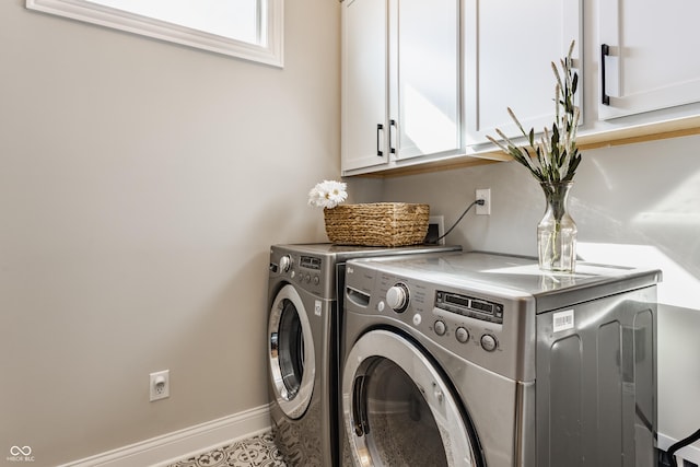 clothes washing area featuring independent washer and dryer, cabinet space, and baseboards