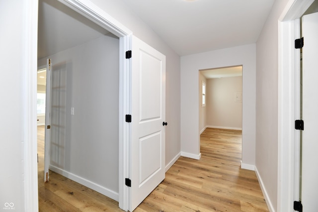 hallway with baseboards and light wood-style floors