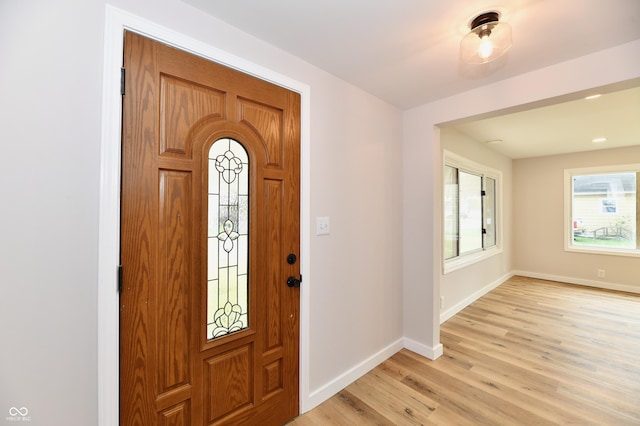 foyer entrance featuring light wood finished floors and baseboards